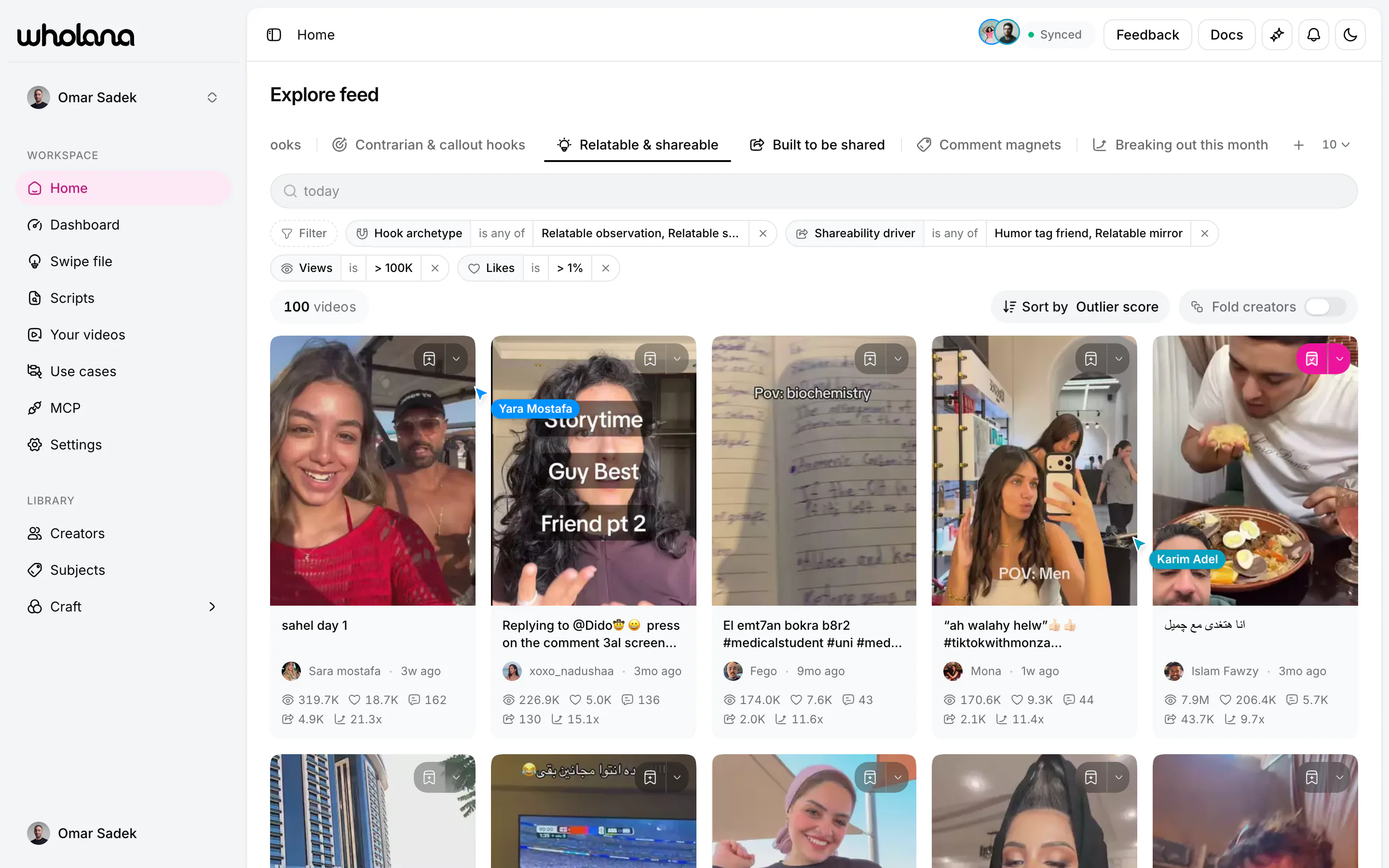 The Wholana Explore feed: a row of saved lenses across the top, an active filter set reading hook archetype is any of “Relatable observation, Relatable s…”, shareability driver is any of “Humor tag friend, Relatable mirror”, views is over 100K and likes is over 1%, then 100 videos sorted by outlier score as a grid of Arabic TikTok thumbnails, each card carrying views, likes, comments, saves and its outlier multiple